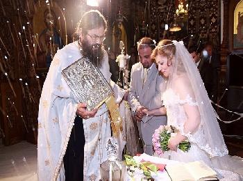 Жених и невеста идут за священником вокруг алтаря